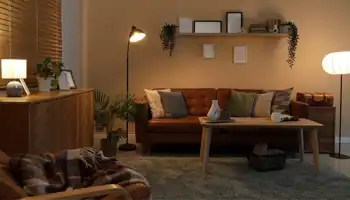 Innenansicht eines dunklen Wohnzimmers mit leuchtenden Lampen, Sofa und Regal bei Nacht